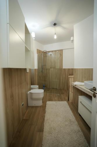 a bathroom with a toilet and a shower and a sink at Praialonga Suites with Pool and Garden in Le Castella