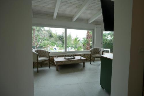 a living room with a table and chairs and a window at Praialonga Suites with Pool and Garden in Le Castella