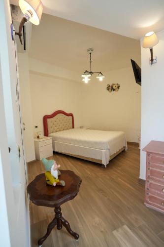 a bedroom with a bed and a table and a chair at Praialonga Suites with Pool and Garden in Le Castella