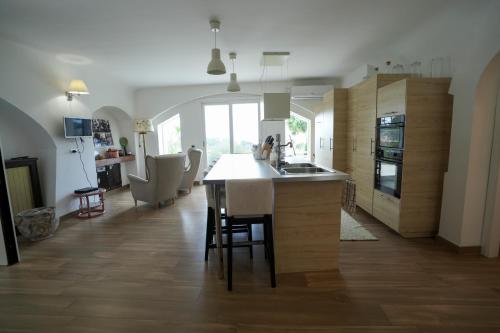 a kitchen with a island in the middle of a room at Praialonga Suites with Pool and Garden in Le Castella