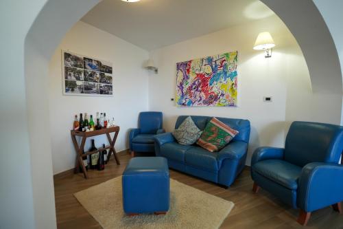 a living room with blue couches and a table at Praialonga Suites with Pool and Garden in Le Castella