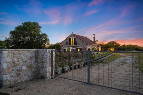 a fence in front of a house with a stone wall at Vila Anita in Trbounje