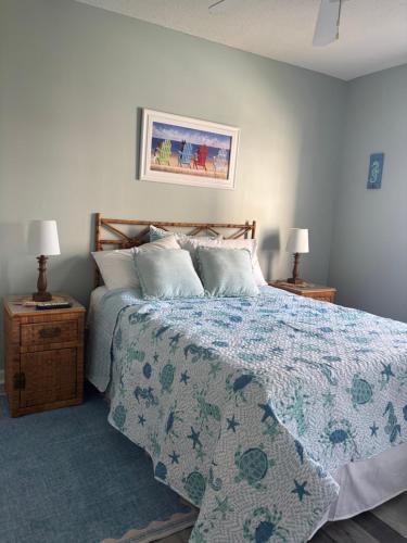 a bedroom with a bed with a blue blanket and two lamps at Breezy Corner in Myrtle Beach