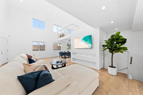 a white living room with a couch and a potted tree at The Diamond Dune Three floors Two Balconies BBQ in Los Angeles