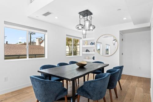 a dining room with a table and blue chairs at The Diamond Dune Three floors Two Balconies BBQ in Los Angeles