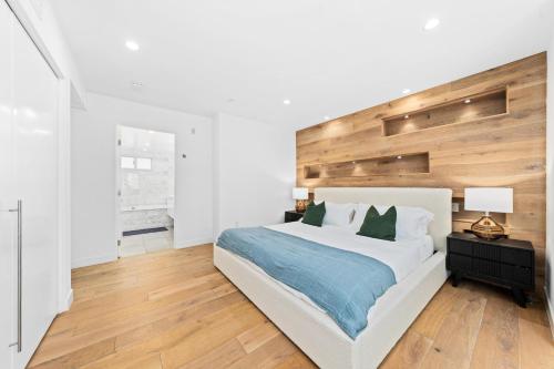 a bedroom with a large white bed with a wooden headboard at The Diamond Dune Three floors Two Balconies BBQ in Los Angeles