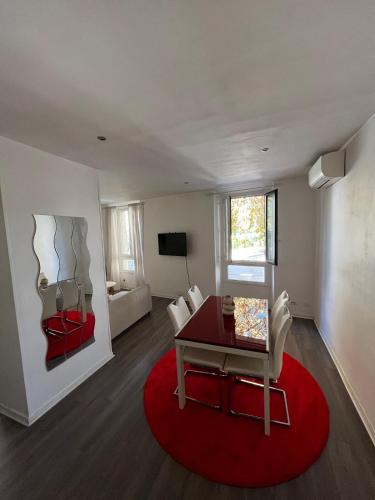 un salon avec une table et un tapis rouge dans l'établissement Cozy apartment in Cannes, à Cannes