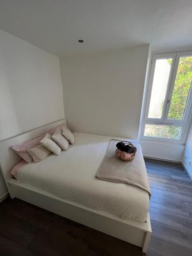 un lit dans une chambre avec une grande fenêtre dans l'établissement Cozy apartment in Cannes, à Cannes