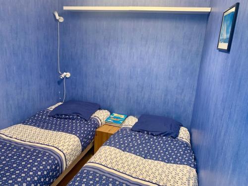 - 2 lits jumeaux dans une chambre aux murs bleus dans l'établissement Studio-alcôve lumineux en front de mer, à Neufchâtel-Hardelot