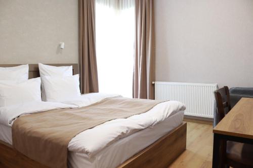 a bedroom with a large bed with a window at Hotel 717 Kazbegi in Stepantsminda