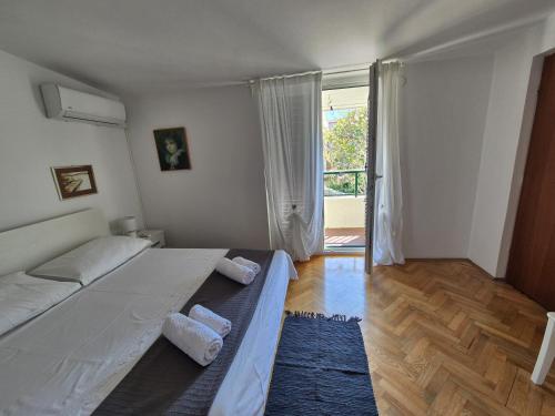 a bedroom with two beds and a large window at Holiday Home Marija in Biograd na Moru