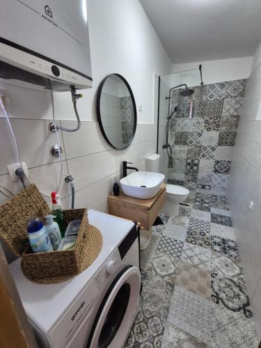 a bathroom with a washing machine and a toilet at Holiday Home Marija in Biograd na Moru