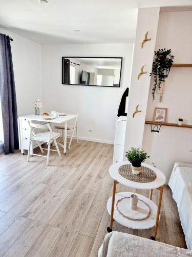 a white living room with a table and a dining room at Le Souffle - Stade de France - in Saint-Denis