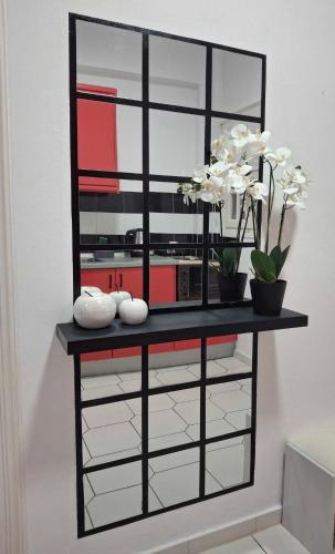 a black shelf with white flowers on top of it at Philippos Apartments in Acharavi