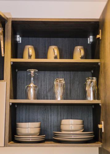 a cabinet filled with plates and cups and dishes at Accra Luxury Apartments @ The Lennox in Accra