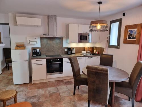 une cuisine avec une table et une salle à manger dans l'établissement Superbe T2 dans le quartier des peintres, au calme, tout confort, à deux pas des plages, clim et wifi, à Collioure