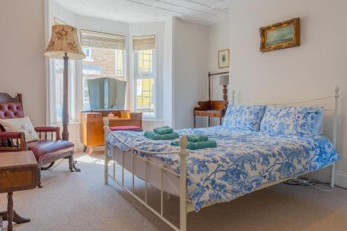 a bedroom with a bed with a blue comforter at Elegant Family Townhouse-Conservation Area-Garden in Kent