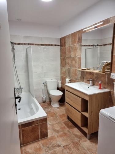 une salle de bain avec une baignoire, un lavabo et des toilettes dans l'établissement Superbe T2 dans le quartier des peintres, au calme, tout confort, à deux pas des plages, clim et wifi, à Collioure