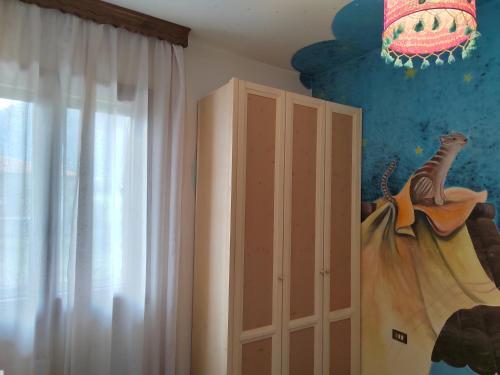 a bedroom with a bed and a curtain and a cabinet at Bed and breakfast santa felicita in Borso del Grappa