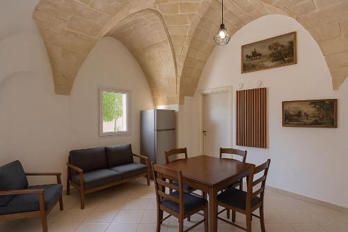 Una cocina y un comedor con mesa y sillas. en Villa il Fagiano, en Nardò