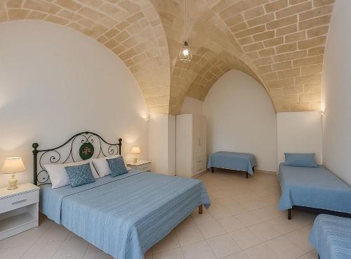 Un dormitorio con una cama grande y una pared de piedra. en Villa il Fagiano, en Nardò