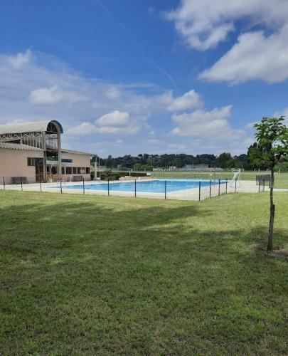 - une piscine dans un champ à côté d'un bâtiment dans l'établissement Village Vacances de Bretou, à Eymet