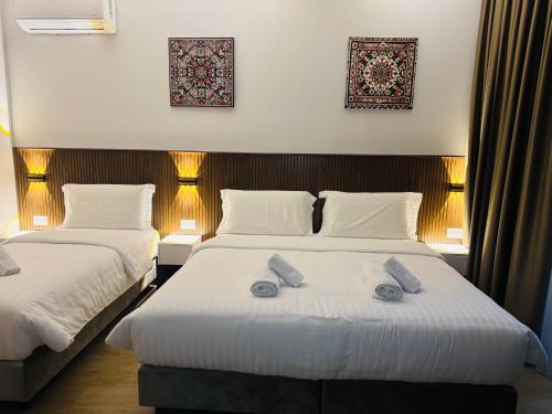 two beds in a hotel room with towels on them at Kruja Townscape Rooms in Krujë