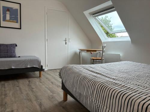 une chambre avec un lit et une fenêtre dans l'établissement Maisonnette bretonne typique Beg Meil Fouesnant Ty Breizh plage, à Fouesnant