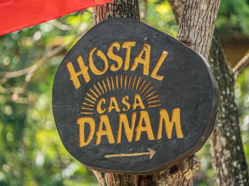 a sign on a tree with the name of a casa channel at Casa Danam in Santa Marta
