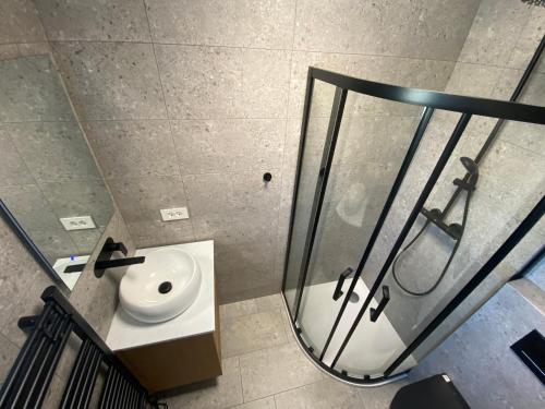 a bathroom with a sink and a glass shower at Blue alpine nest Komenda in Komenda