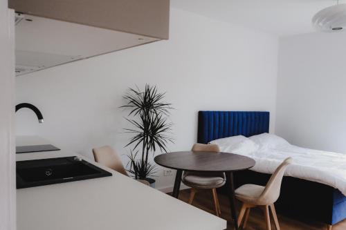 a bedroom with a bed and a table and chairs at Blue alpine nest Komenda in Komenda