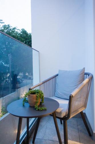 a bench on a balcony with a table and a pillow at Accra Luxury Apartments @ The Lennox in Accra