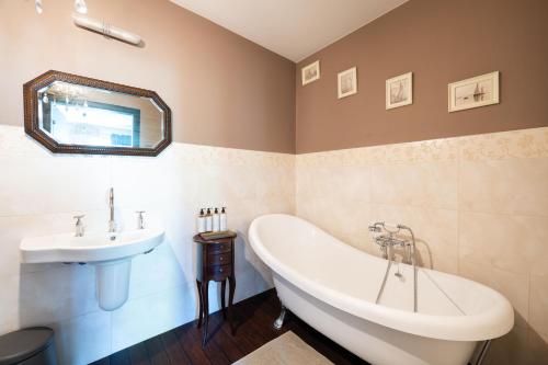 a bathroom with a white tub and a sink at Baltic Breeze Lodge in Gdynia