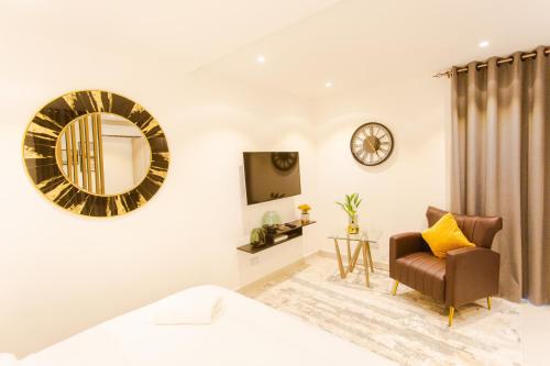 a living room with a chair and a mirror at Accra Luxury Apartments @ The Lennox in Accra