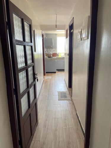 an empty hallway with a door and a kitchen at Appartement lumineux avec vue mer à Sidi Rbat Entre nature et océan in Sidi Rbat