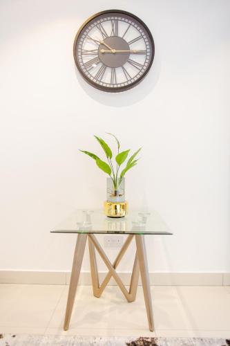 a glass table with a clock on a wall at Accra Luxury Apartments @ The Lennox in Accra