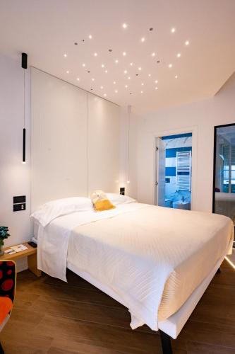 a bedroom with a large white bed with lights on the ceiling at Incanto in Cosenza