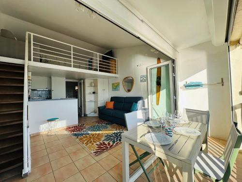 un salon avec une table et un canapé dans l'établissement le petit mouillage, à 100 m de la plage, à Grimaud