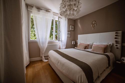 Un dormitorio con una cama grande y una ventana. en Villa de Charme avec Piscine Calme & Élégance, en Aubenas