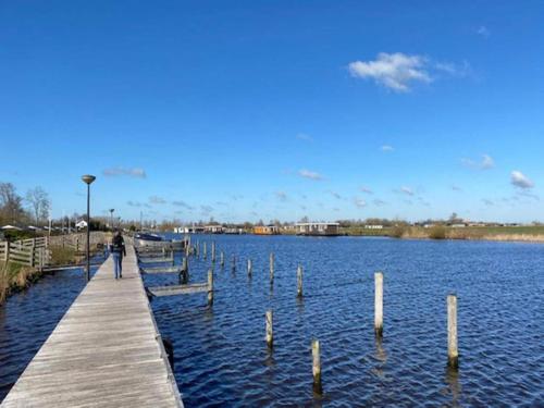 a person walking on a dock in the water at Holiday Home in Yn e Lijte with Water Sports in Grou