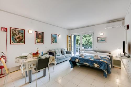 a bedroom with a bed and a desk and a couch at Residenza Lago D'Argento - Happy Rentals in Riva del Garda