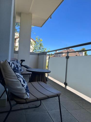 a patio with a bench and a table on a balcony at Baltic Breeze Lodge in Gdynia