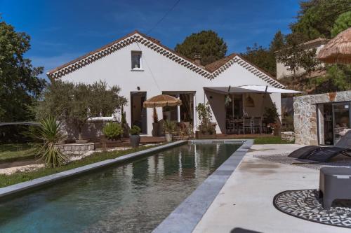 a villa with a swimming pool in front of a house at Villa de Charme avec Piscine Calme & Élégance in Aubenas