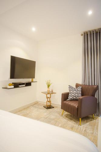 a living room with a couch and a tv at Accra Luxury Apartments @ The Lennox in Accra