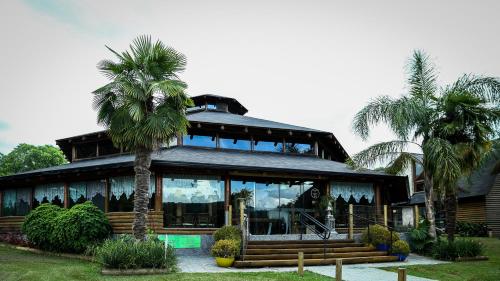a house with palm trees in front of it at Virá Charme Resort in Fernandes Pinheiro