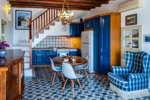 uma cozinha com armários azuis e uma mesa e cadeiras em Nearchos House em Plaka Milou
