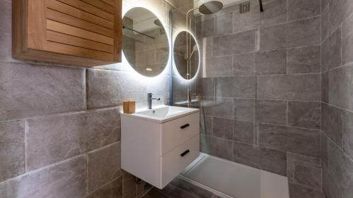 une salle de bain avec un lavabo blanc et un miroir dans l'établissement T2 Parking à 1000m du Lac, à Annecy