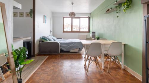 une chambre avec un lit, une table et des chaises dans l'établissement T2 Parking à 1000m du Lac, à Annecy
