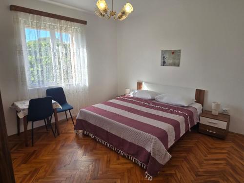 a bedroom with a bed and a desk and a window at Apartment Tome in Biograd na Moru