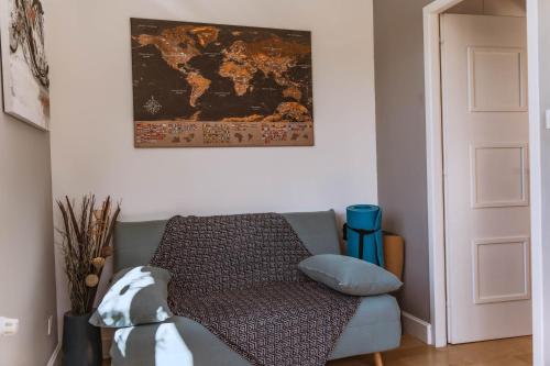 a living room with a couch and a map on the wall at Villa de Charme avec Piscine Calme & Élégance in Aubenas